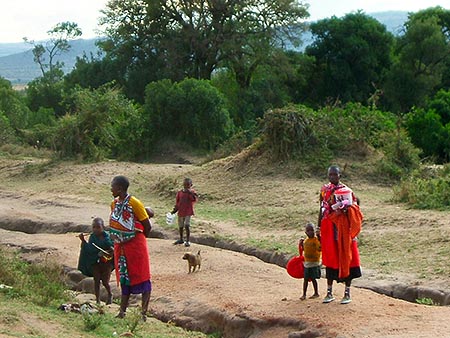 Las mujeres y los niños van hacia una charca donde hacer la colada